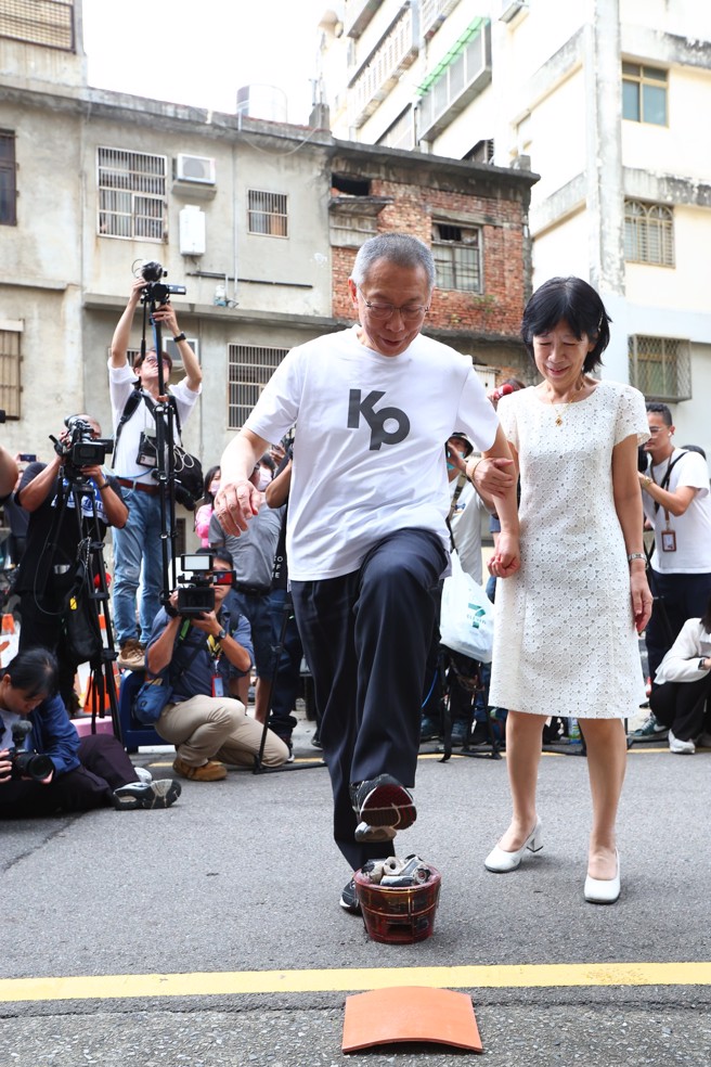 民眾黨前主席柯文哲裁定7000萬元交保，8日下午交保離開法院後，直接返回新竹老家。柯文哲(左)在妻子陳佩琪(右)陪伴下跨過火爐、踩碎瓦片。（資料照片/鄧博仁攝）