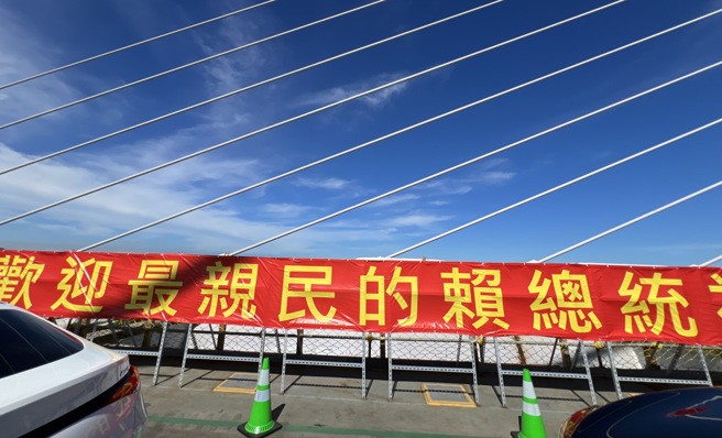 交通部公路總局16日在新北市淡水舉行的淡江大橋合龍典禮，現場掛起「歡迎最親民的賴總統」紅布條，熱情迎接賴清德總統蒞臨。（鄧博仁攝）
