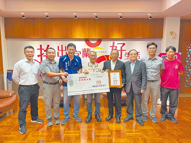 劍潭古寺總幹事蔡國嶼（右四）16日率隊將100萬元善款交給宜蘭縣政府支持弱勢家庭脫貧方案，代理縣長林茂盛（左四）代表接受並頒贈感謝狀。（吳佩蓉攝）