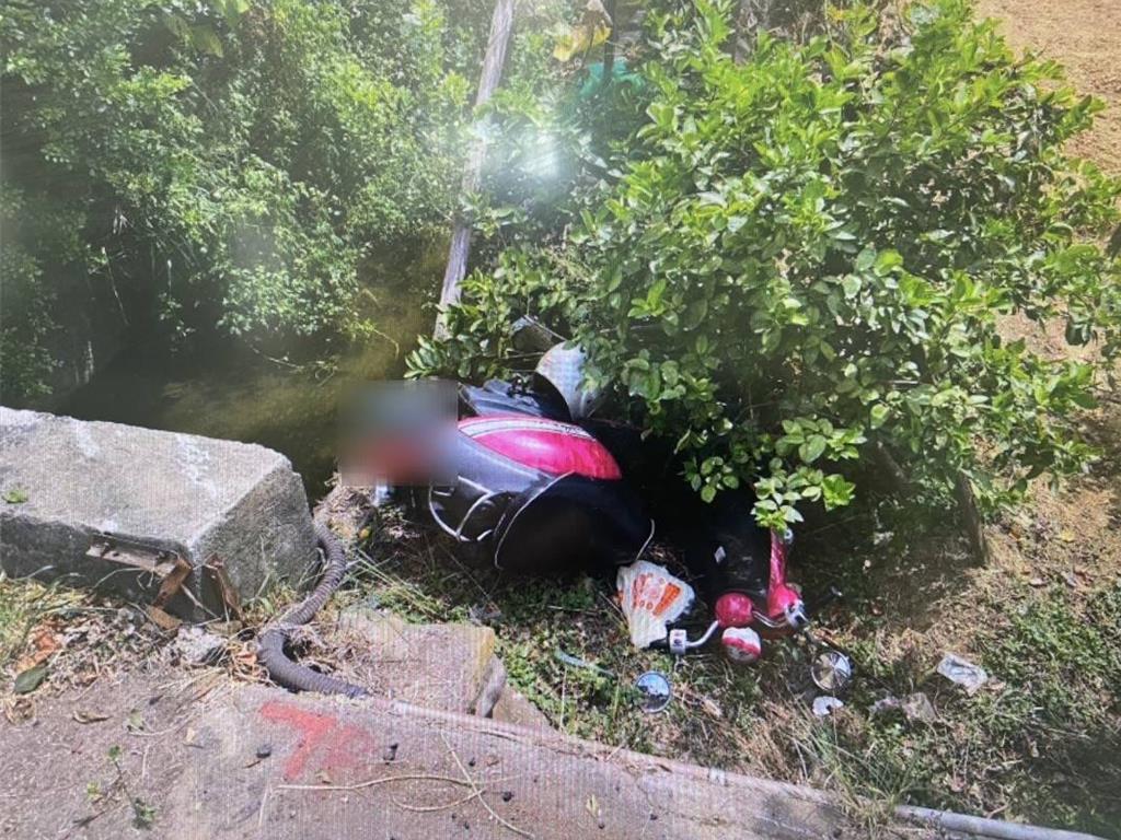 17日上午11時許，66歲婦人騎車載著27歲乘客，行經南竹路四段137巷口時，因道路坑洞影響行車方向，導致2人摔落道路旁低地處，落差約1公尺高的樹叢雜草土堆。（蘆竹警局提供）