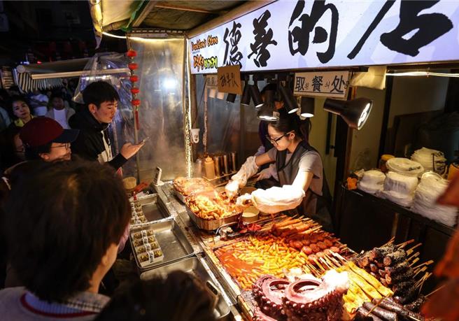 陸專家解讀20項任務升級全齡友好型品質一刻鐘生活圈。圖為遊客在瀋陽市西塔商圈選購美食。（新華社）