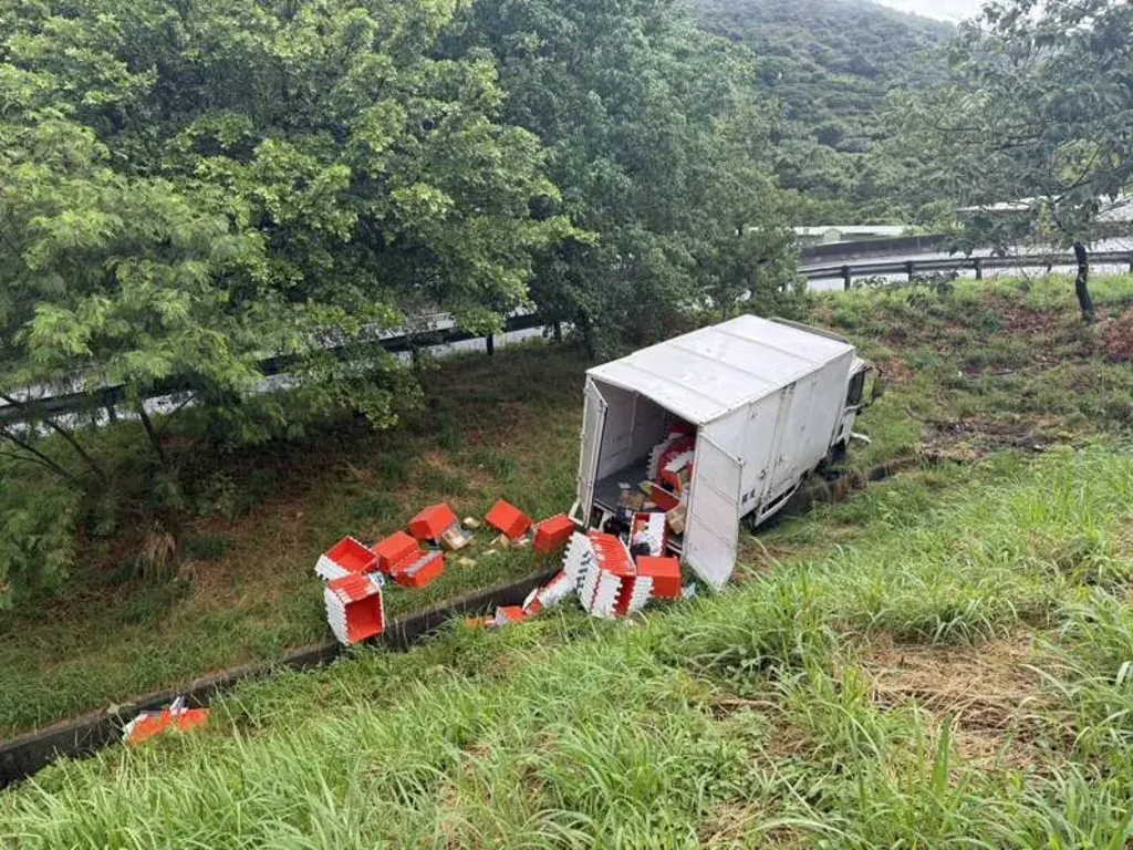 貨車急煞失控，撞破護欄車輛翻落邊坡，物品散落一地。（翻攝畫面）