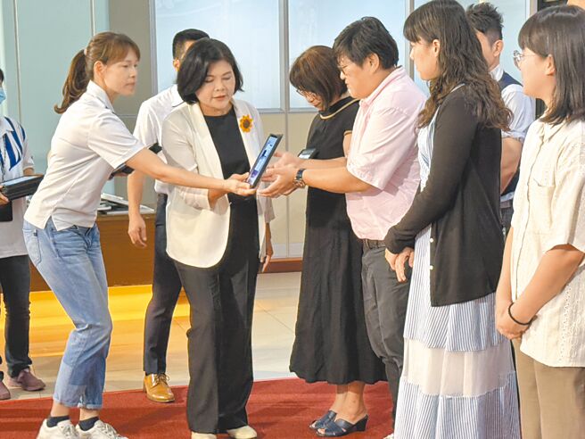雲林縣長張麗善（左二）25日以平板電腦頒發證書給受獎人，因頒獎前走路不慎滑倒，她全程以右手頒發。（周麗蘭攝）