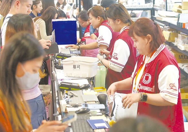 勞動部最低工資審議會26日決議明年最低工資漲3.18%，月薪從新台幣2萬8590元調高到2萬9500元、時薪從190元調漲到196元，後續將送行政院核定。圖為世貿一館舉行的美容展，工作人員忙著幫顧客結帳。（趙雙傑攝）