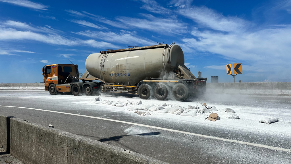 一輛由楊姓男子（26歲）駕駛的營業貨運曳引車，2日中午行經新北市貢寮區台2線78.4公里處、基隆往宜蘭方向時，車上載運的大量袋裝工業石粉突然崩落，瞬間佔據整個車道，現場宛如被白色粉塵淹沒，嚴重影響交通。（圖／簡銘柱翻攝）