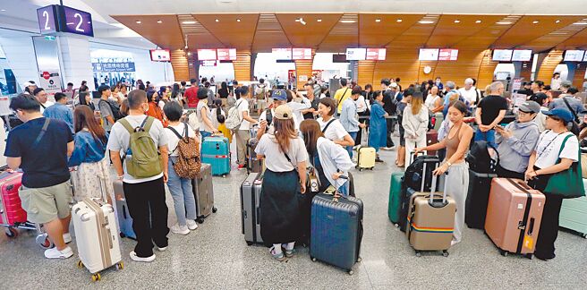 许多民眾趁着中秋假期后紧接国庆连假规画出国旅游，据桃园机场公司预估，连假旅运高峰期间为10月3日至13日，入出境旅客数上看151万人次。图为桃园机场第一航厦出境大厅，旅客准备办理报到手续。（范扬光摄）