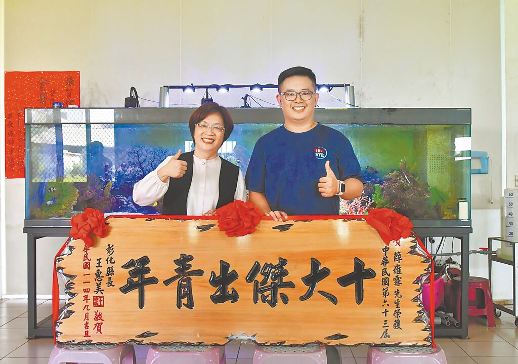 彰化青年薛雍霖（右）投入小丑魚繁殖，開發出35個品系行銷全球14個國家，獲第63屆十大傑出青年，縣長王惠美致贈匾額恭賀。（彰化縣政府提供／葉靜美彰化傳真）