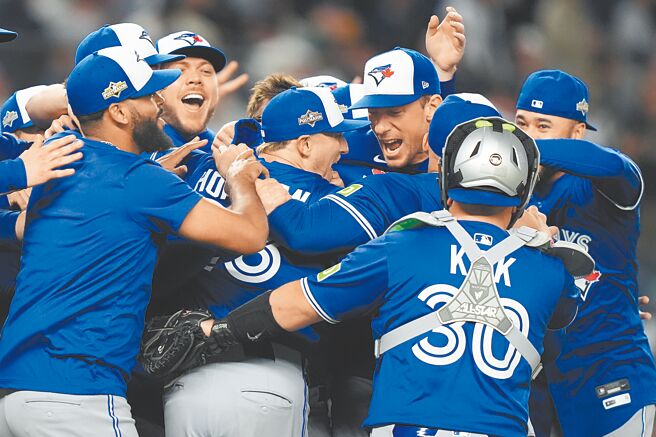 蓝鸟在分区赛G4击败洋基后，全队衝上投手丘庆祝晋级。（美联社）