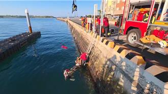 老翁不明原因落海緊抓鐵鍊待援  警消架掛梯繩索拖拉上岸