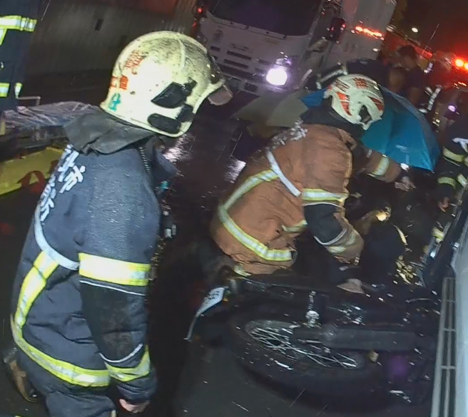 新北市板桥区大观路一段，发生汽机车车祸，骑士右脚受困轮胎下，所幸救出送医时意识清楚。（民眾提供）