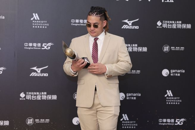 味全龙吉力吉捞·巩冠顶着华丽的编髮，身穿奶茶色西装、繫上红底白点领带，个人风格鲜明。（杜宜谙摄）