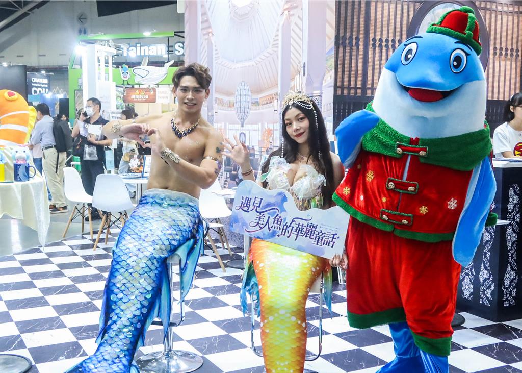 遠雄海洋世界的人魚表演者在旅展現場與民眾互動。(粘耿豪攝)