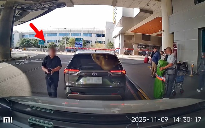 違規的白牌司機下車幫忙上行李，不時觀看旁邊是否有警察。（翻攝爆料公社）