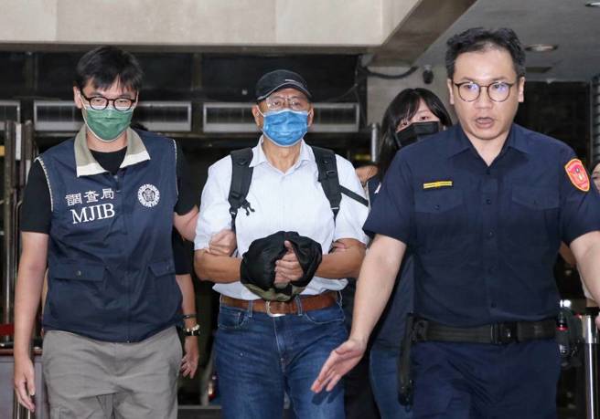 傅崐萁管家李慶隆（後中），在遭通緝一周後，由律師陪同向調查局北機站投案，調查官依法逮捕，訊後移送北檢歸案。（中時資料庫）