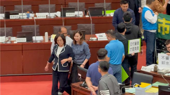 高市議長康裕成（左前）趁混亂，離開議事廳。（柯宗緯攝）