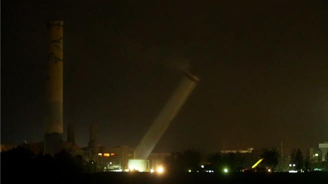 苗栗通霄火力发电厂第5号旧烟囱昨晚顺利「放倒」，高120公尺地标伴随巨响倒地，吸引在地民眾围观。（读者提供／吕丽甄苗栗传真）