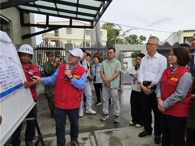 凤凰颱风来袭，屏东县长周春米（右二）11日到东港大潭滞洪池与新园C干线抽水站视察防颱整备，听取水利处长江国丰（左一）简报。（罗琦文摄）