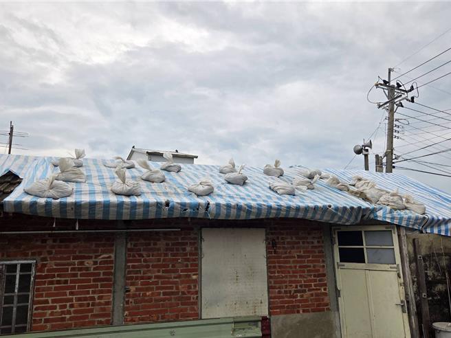 丹娜絲風災過後仍有少部分受損房屋屋頂暫以帆布覆蓋，因應鳳凰颱風來襲，今天各區公所也加強確認帆布固定，屋頂堆滿沙包避免二度受災。(台南市政府提供／曹婷婷台南傳真)