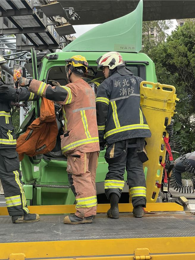 2025年11月11日新北市／貨櫃車碰撞砂石車後駕駛癱坐在車內、沒有動靜，警消急破窗救人。（國道公路警察局提供／吳嘉億新北傳真）
