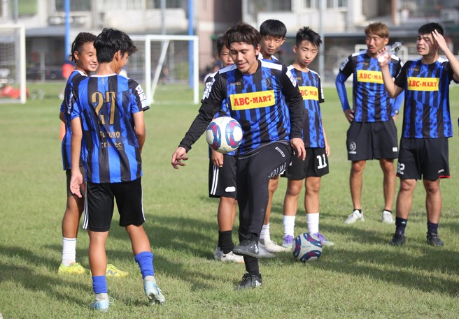 柏木陽介（中）玩球技術讓小球員看得津津有味。（李弘斌攝）