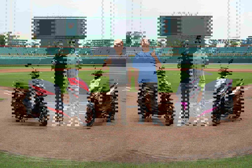 光陽為慶祝RTSR代言人陳傑憲（右）榮獲「外野金手套」肯定，光陽集團總經理徐文元（左）特別安排兩款最新的特仕版「摩力紅」、「紫暴銀」與陳傑憲合體曝光。（光陽提供）
