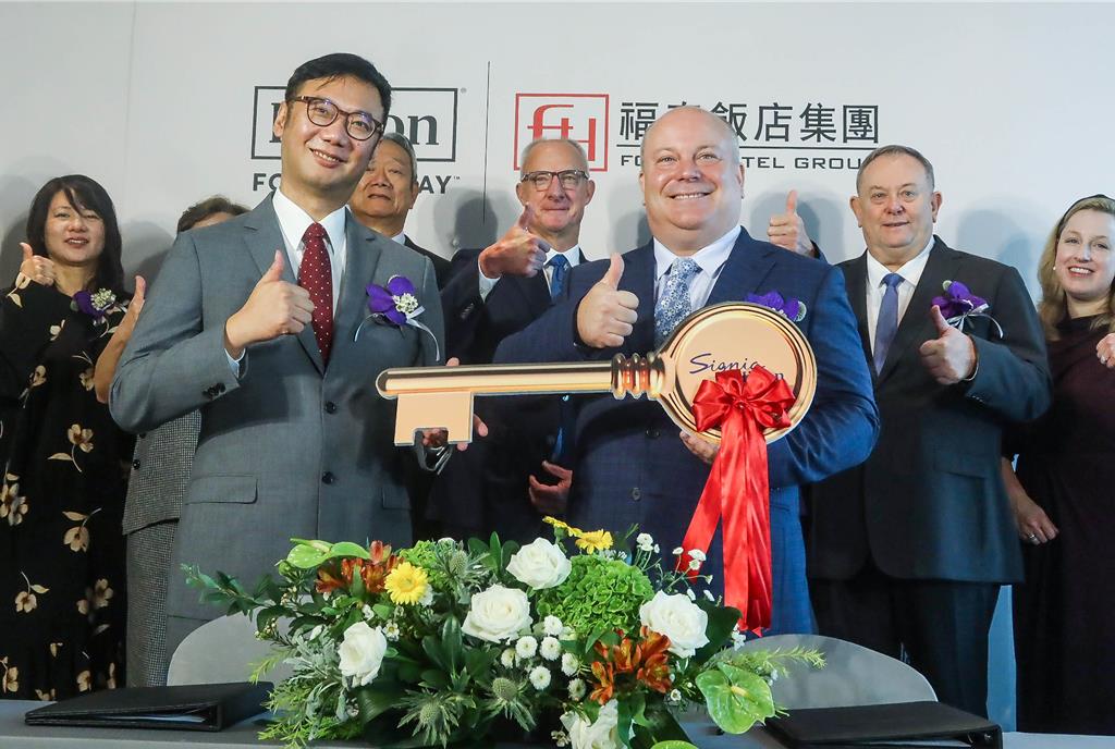 福泰飯店集團與希爾頓集團打造「台南Signia by Hilton酒店」，記者會上福泰飯店集團董事長廖炳燿（前左）將鑰匙交給台南Signia by Hilton總經理Chris Roberts（前右）。（粘耿豪攝）