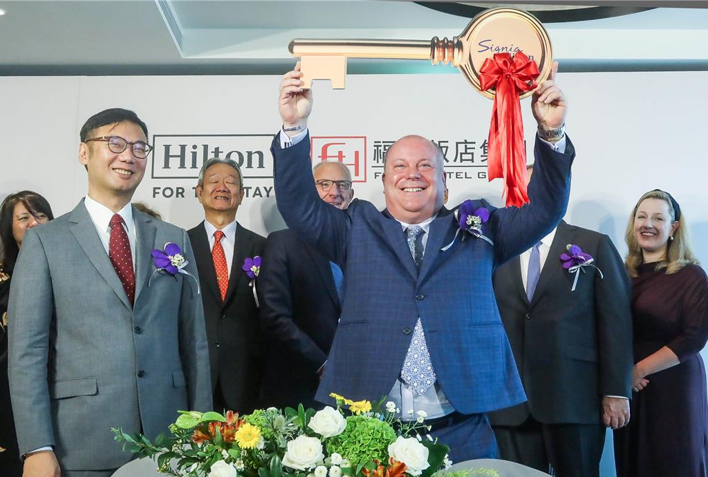 福泰飯店集團與希爾頓集團打造「台南Signia by Hilton酒店」，記者會上福泰飯店集團董事長廖炳燿（前左）將鑰匙交給台南Signia by Hilton總經理Chris Roberts（前右）。（粘耿豪攝）