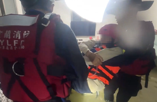 消防人員協助行動不方便的男子脫困。（圖／翻攝畫面）
