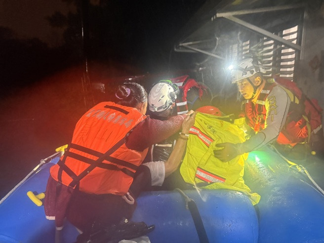 消防人員協助行動不方便的男子脫困。（圖／翻攝畫面）