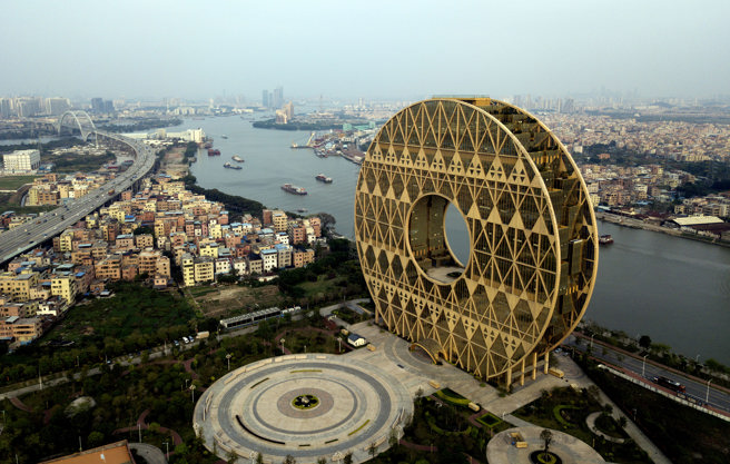 這座由意大利建築師設計外形獨特的大廈位於廣州市荔灣區白鵝潭的江邊。圖為廣州圓大廈空拍畫面。（圖／中新社資料照）