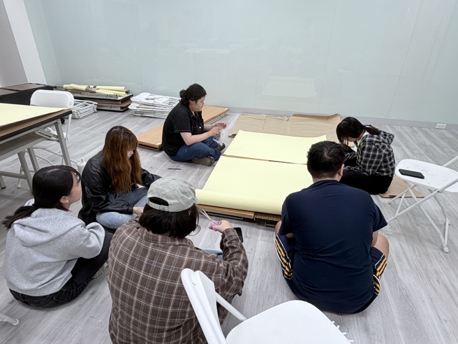 南華大學文創系以辦桌文化展現創意實踐，畢業展將於12月12日登場，學生們進行展場佈置。（南華大學提供）