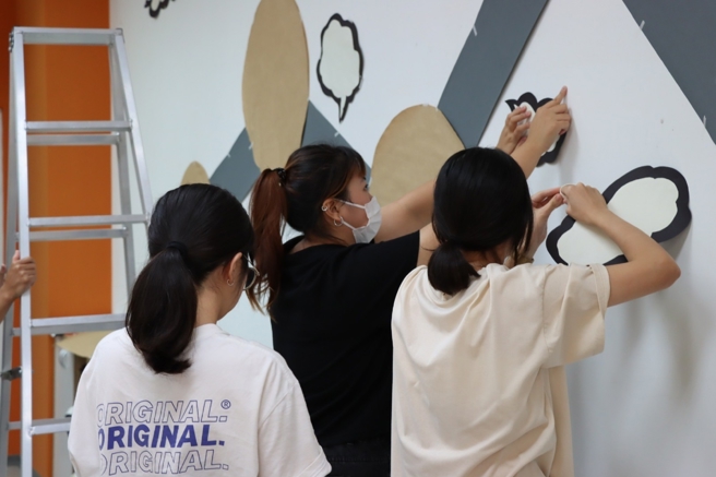 南華大學文創系以辦桌文化展現創意實踐，畢業展將於12月12日登場，學生們進行展場佈置。（南華大學提供）