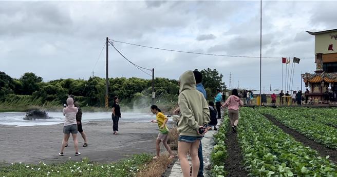 輕颱鳳凰尚未登陸，屏東萬丹泥火山12日搶先噴發，由於屏東天氣陰涼無雨，因此吸引不少人潮前往「朝聖」，大批民眾搶拍泥火山噴發，意外成為颱風天奇景。（謝佳潾攝）