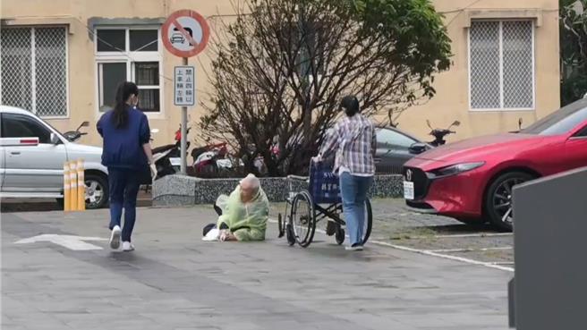 澎湖上午虽已脱离轻颱凤凰暴风圈，但仍风势强劲，一名路过卫生福利部澎湖医院停车场的长者不慎跌倒，瘫坐地上，幸急诊室护理人员听到呼唤，连忙推轮椅过去扶起，并推至急诊室内检查。（民眾提供／许逸民澎湖传真）