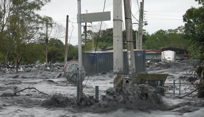 花蓮萬榮鄉明利村遭滾滾泥流灌入，還可見貨櫃直接撞斷電線桿。（圖／網友@fishhead_insane授權提供）