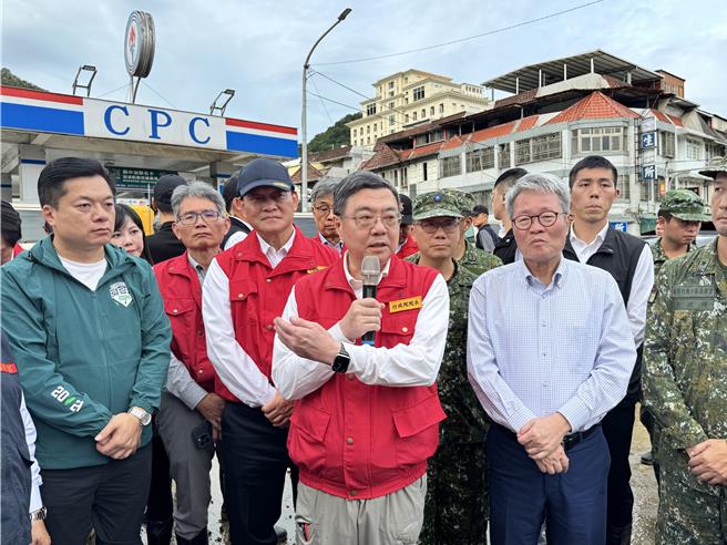 行政院长卓荣泰（红色背心）缓解军方紧张气氛的说，「压坏的两部车子不用担心，我跟顾部长一人赔一台！」（吴佩蓉摄）