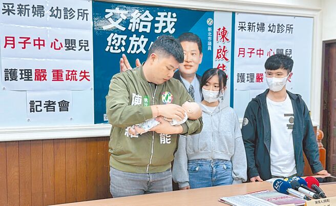 陈启能办公室执行长陈俊维（左）11日在记者会上，现场示范「支撑头颈、稳定托举」的正确抱婴姿势。（张铠乙摄）