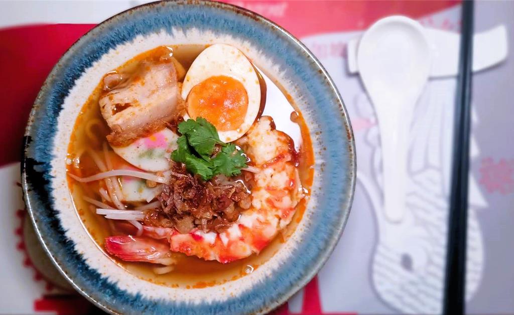 「主廚特製明蝦拉麵」以濃郁鮮甜的蝦湯融合日式湯底與星洲香料,湯頭鮮醇厚實,明蝦彈牙。(陳韻萍攝)