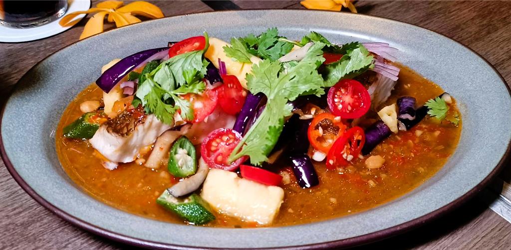 「娘惹酸甜椒醬酥炸海魚」以鳳梨、秋葵與辣椒堆疊出酸香辣韻,堪稱白飯小偷。(陳韻萍攝)