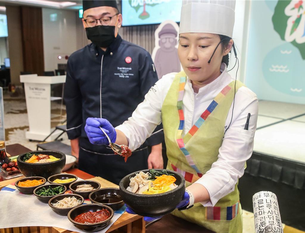 點心房主廚 Sienna Wang (前)示範韓國傳統美食「韓式拌飯」。 (粘耿豪攝)