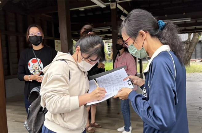今趁送孩子上学的机会，陆续有家长签下连署书。(吕妍庭摄)