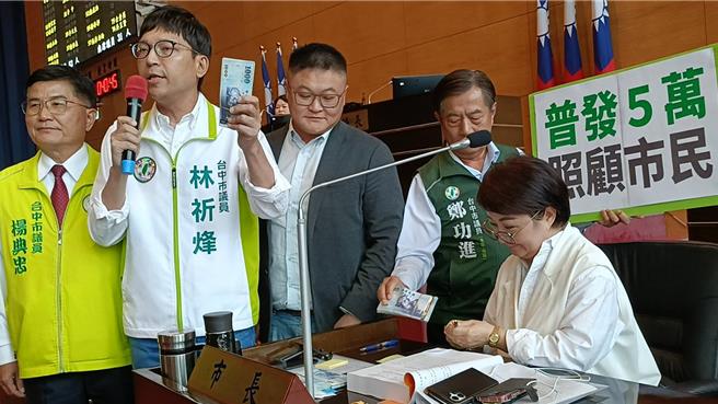 民進黨台中市議員林祈烽（左二）、鄭功進（右二）、楊典忠（左一）、施志昌（右三）則各自手拿1疊5萬元現金走到市長盧秀燕（右一）旁質詢。（陳淑娥攝）