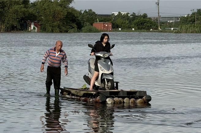 一名林姓护理师为赶赴医院照顾病人，竟冒险把机车骑上竹筏「渡水上班」，父亲在旁涉水护送。（张亮轩提供／吴佩蓉宜兰传真）