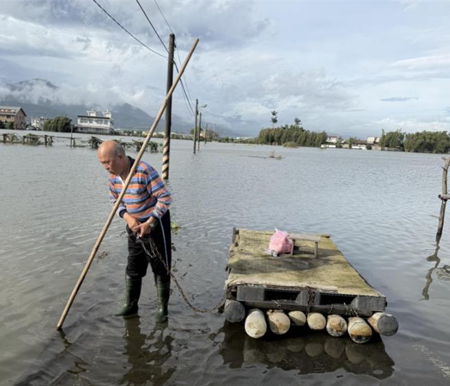 一名林姓护理师为赶赴医院照顾病人，竟冒险把机车骑上竹筏「渡水上班」，父亲在旁涉水护送。（张亮轩提供／吴佩蓉宜兰传真）