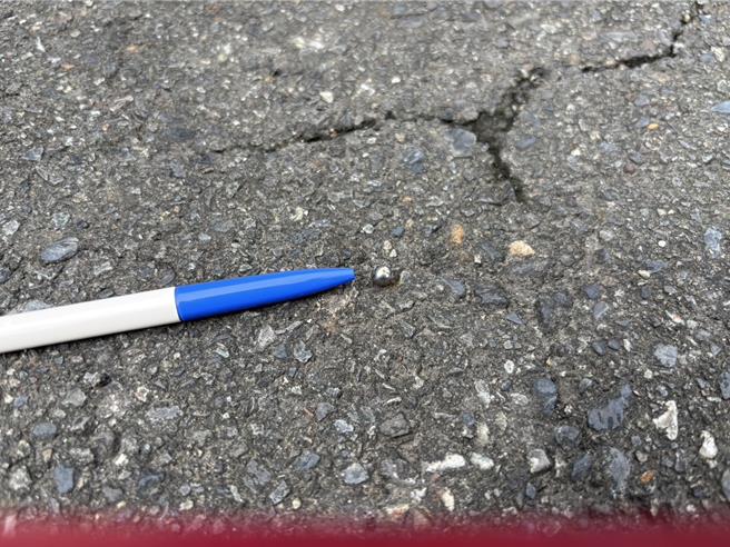 員警趕抵現場後發現玻璃出現裂痕但未貫穿，地面並留有一顆鋼珠，研判可能是彈弓或空氣槍所致。（警方提供／林雅惠高雄傳真）