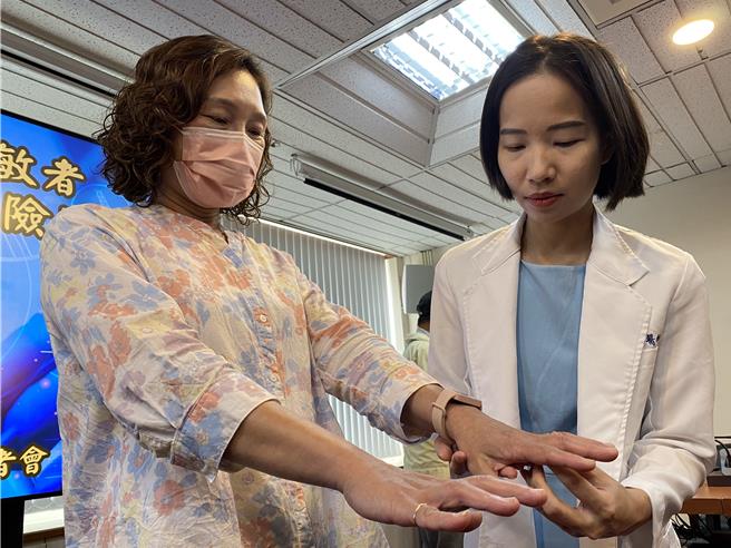 台中榮總過敏風濕免疫及一般內科醫師陳韻文(左)為病人江小姐(右)檢查乾燥症相關的手指關節腫痛症狀。（陳淑娥攝）