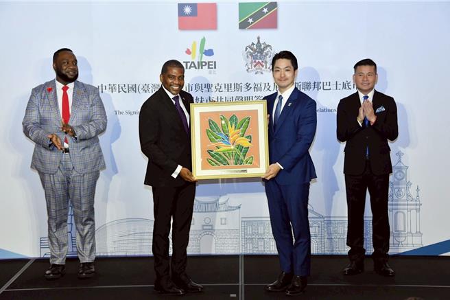 台北市長蔣萬安13日出席「台北市與巴士底市締結姊妹市共同聲明簽署典禮」，致贈台北市市鑰予聖克里斯多福及尼維斯聯邦總理德魯，德魯總理則回贈裱框蠟染畫作。（台北市政府提供／丁上程台北傳真）