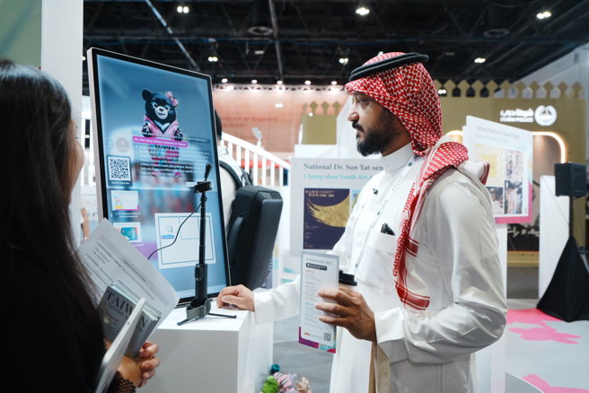 国际友人前来体验臺湾馆的AI导览机，与臺湾黑熊AI助理一贝儿互动，认识臺湾各个博物馆。(中华民国博物馆学会提供)