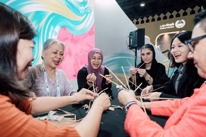 来自不同种族、宗教的参观人士来到臺湾馆了解传统文化，并且由蔺草编织工艺师吕锦霞带领进行客家蔺草编织体验。(中华民国博物馆学会提供)