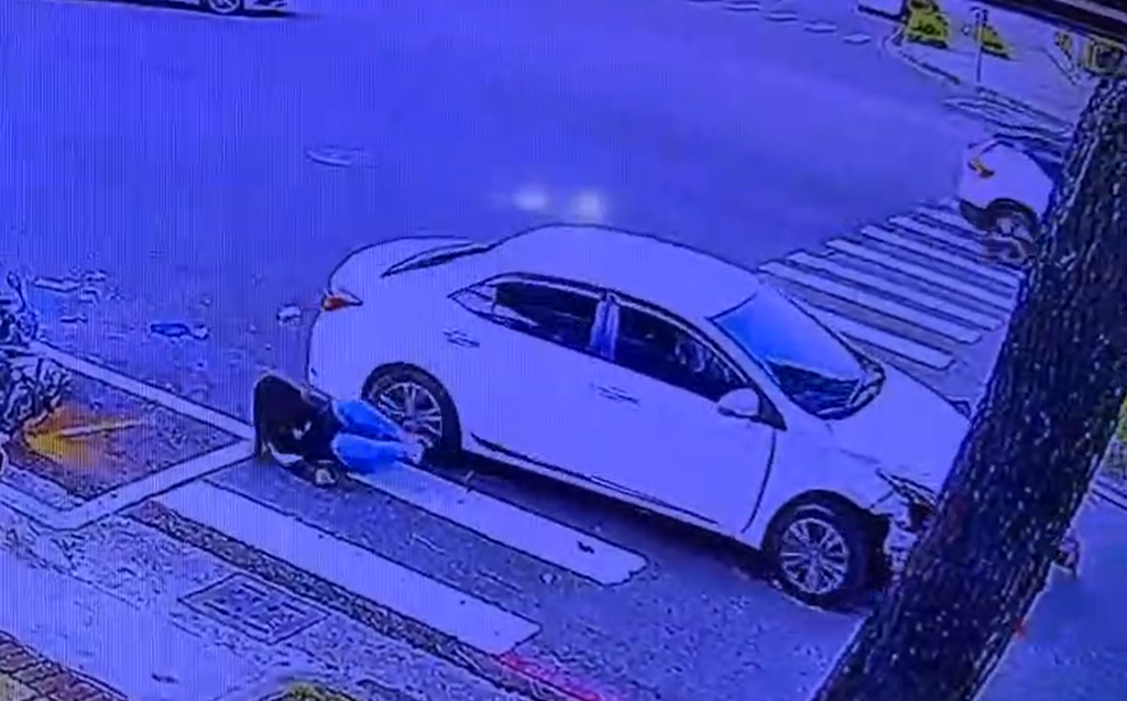 轎車撞待轉區如保齡球,她急縮腳險被輾。(圖/翻攝畫面)